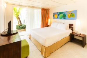 1 dormitorio con 1 cama y TV en Decameron Los Delfines - All Inclusive, en San Andrés