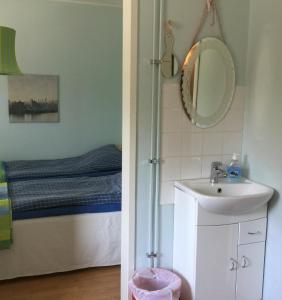 La salle de bains est pourvue d'un lavabo et d'un miroir. dans l'établissement E-City B&B, à Tornio