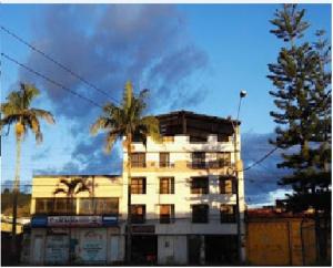 a tall building with palm trees in front of it at Hotel Casa del Abuelo in Popayan