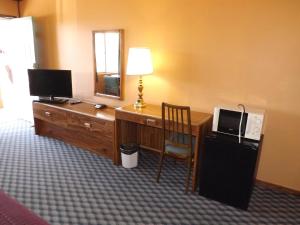 Habitación con escritorio, ordenador y espejo. en Tristar Inn Xpress en Tucumcari