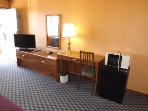 a room with a desk with a computer and a mirror at Tristar Inn Xpress in Tucumcari