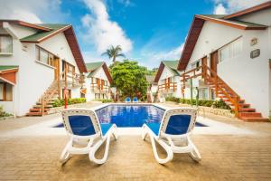 two chairs and a pool in front of a house at Decameron San Luis - All Inclusive in San Andrés