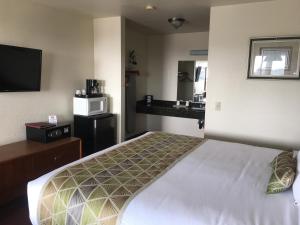 a hotel room with a bed and a sink at Westward Inn in Brookings