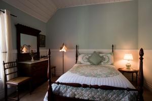ein Schlafzimmer mit einem Bett, einer Kommode und einem Spiegel in der Unterkunft Avery Hotel in Avery
