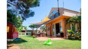 une maison avec un jouet vert dans la cour dans l'établissement Villa Gerani, à Gerani