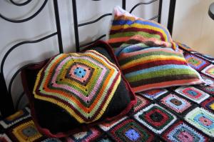 2 cuscini a maglia posti sopra un letto di Adega da Figueira a Calheta de Nesquim