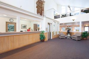 a lobby of a hospital with a woman at the counter at Fernie Slopeside Lodge in Fernie