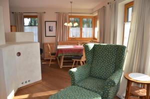 salon z zielonym krzesłem i stołem w obiekcie Haus Enzian w mieście Seefeld in Tirol