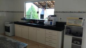 a kitchen with a sink and a microwave oven at Sítio Gazotti Marina in Capitólio