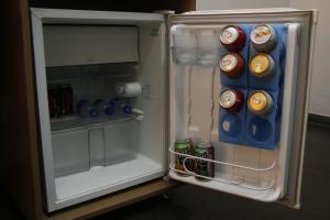 an open refrigerator with cans of soda in it at Hotel Santa Fé in Itupeva