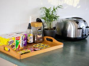a wooden cutting board with food and drinks on a counter at SkyLodge Temora in Temora
