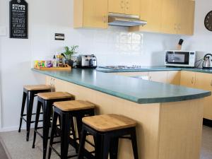 uma cozinha com bancada azul e bancos em SkyLodge Temora em Temora
