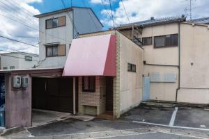 an old building with a red awning on it at Calligraphy House in Kyoto