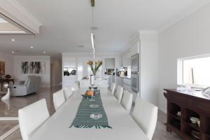 a white dining room with a white table and white chairs at Epsom on Swan Bed & Breakfast in Perth