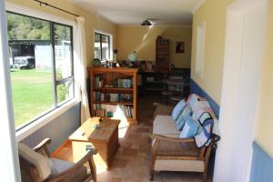 salon z kanapą, krzesłami i stołem w obiekcie Kahurangi Cottage Wilderness Retreat w mieście Stanley Brook