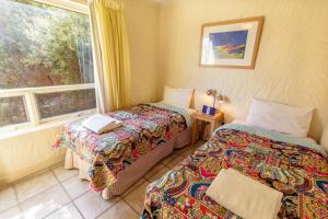 a room with two beds and a window at Bayswaterfront Apartments in Adelaide
