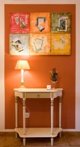 Bustio的住宿－La Fonda de Bustio，一张桌子,上面有台灯和墙上的绘画