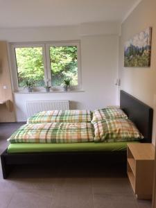 una camera con un letto verde con due finestre di Bergcafè - Hotel Kammann a Essen