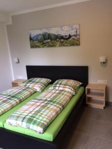 een slaapkamer met een bed met een geruite dekbed bij Bergcafè - Hotel Kammann in Essen