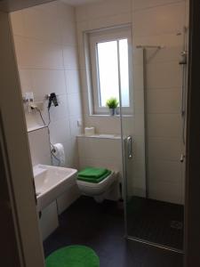 e bagno con servizi igienici, lavandino e doccia. di Bergcafè - Hotel Kammann a Essen