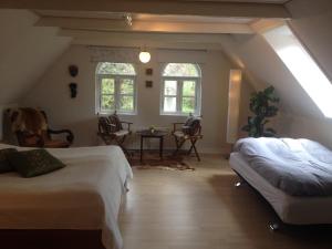 a attic room with two beds and a table and chairs at Kildegaarden Bed & Breakfast in Frørup +55 photos