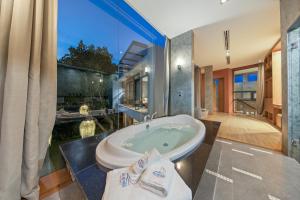 a bathroom with a tub and a large window at Villa Sea Senses in Choeng Mon Beach