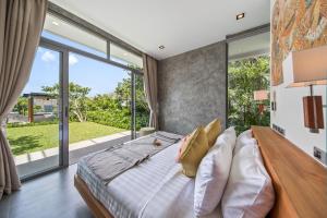 a bedroom with a large bed and a large window at Villa Sea Senses in Choeng Mon Beach