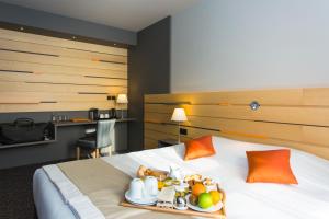 a hotel room with a tray of food on a bed at Logis Hôtel du Morvan - Restaurant la Table de Jérôme in Luzy
