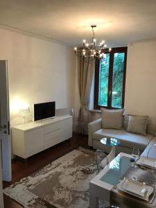 sala de estar con sofá y TV en Parco Villa San Vigilio en Garda