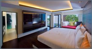 - une chambre avec un grand lit blanc et une télévision dans l'établissement Aava Resort and Spa, à Khanom