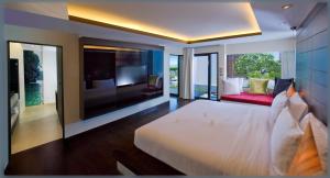 a bedroom with a large white bed and a television at Aava Resort and Spa in Khanom