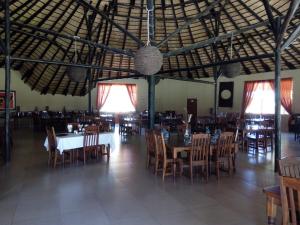 a dining room with tables and chairs in a building at Xain Quaz Camp in Gobabis