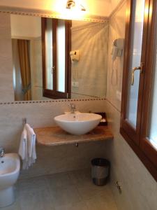 a bathroom with a sink, toilet and mirror at Ca' Dei Polo in Venice