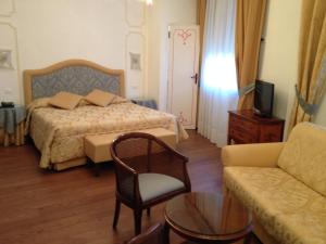 a hotel room with a bed, chair, desk and television at Ca' Dei Polo in Venice