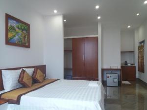 a bedroom with a large white bed and a cabinet at Haengbok Hotel in Bắc Ninh