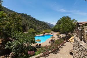 uma vista para uma piscina com guarda-sóis em CALERILLA Hotel em Burunchel