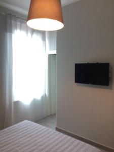 ピエトラサンタにあるAppartamento "La Roby"のベッドルーム1室(ベッド1台、壁掛けテレビ付)