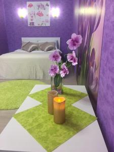 トヴェリにあるApartment on Oktyabrsky 99のベッド1台と花のテーブルが備わるお部屋
