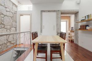 comedor con mesa de madera y sillas en House Cedofeita, en Oporto