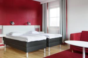 a bedroom with a bed and a red wall at Comfort Hotel Arctic in Luleå