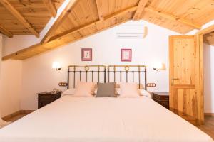 Schlafzimmer mit einem großen Bett und Holzdecken in der Unterkunft CALERILLA Hotel in Burunchel