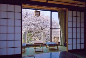 a room with a large window and a table and chairs at Mikasa in Nara