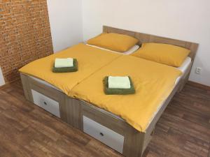 2 camas en una habitación con sábanas y almohadas amarillas en Penzion Eden Turnov, en Turnov