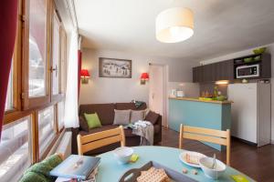 een keuken en een woonkamer met een tafel in een kamer bij VVF Val-Cenis Haute-Maurienne in Lanslevillard