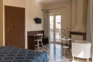 1 dormitorio con cama, escritorio y balcón en Albergo Carpino, en Mangone