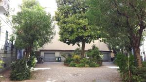 a house with two garage doors and trees at Bronzino House in Milan