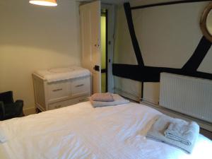 - une chambre avec un lit blanc et des serviettes dans l'établissement Anchor Inn Fladbury, à Fladbury