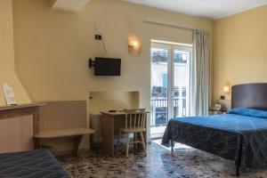 a hotel room with a bed and a desk and a table at Albergo Carpino in Mangone