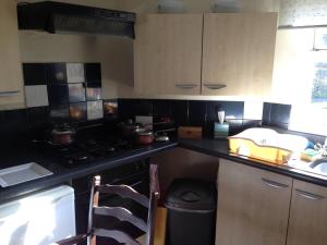 a small kitchen with a stove and a sink at Anchor Inn Fladbury in Fladbury