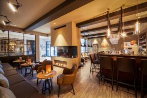 a restaurant with a bar and a chef preparing food at Küstenperle Strandhotel & Spa in Büsum
